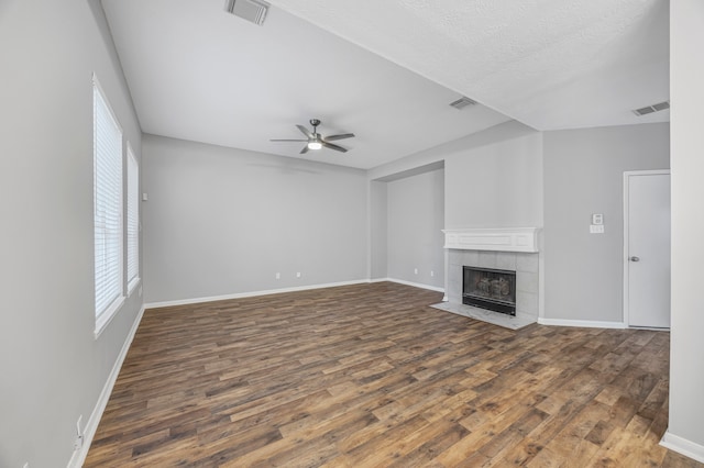 3307 La Seine Ln, Spring, TX 77388 - unfurnished living room with healthy amount of natural light, wood finished floors, ceiling fan, a tile fireplace, and a textured ceiling