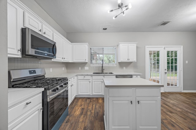 3307 La Seine Ln, Spring, TX 77388 - kitchen featuring stainless steel appliances, dark wood-style flooring, a textured ceiling, backsplash, and light countertops