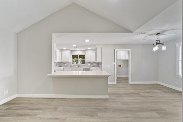 2915 Katy Hockley Rd, Katy, TX 77493 - kitchen featuring lofted ceiling, light countertops, white cabinets, decorative backsplash, and a peninsula