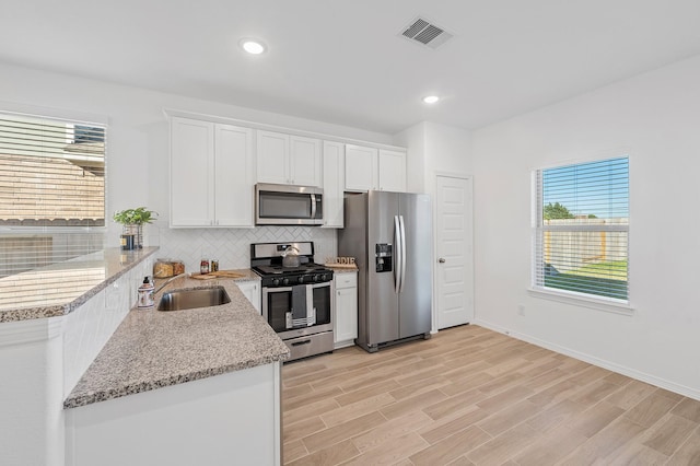 5630 Tabula Rasa Dr, Katy, TX 77493 - kitchen with stainless steel appliances, plenty of natural light, decorative backsplash, white cabinets, and recessed lighting