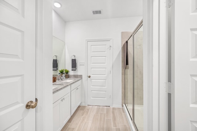 5630 Tabula Rasa Dr, Katy, TX 77493 - full bathroom featuring double vanity, a stall shower, and wood finish floors