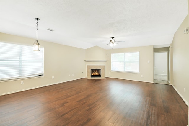 6611 Atasca Creek Dr, Humble, TX 77346 - unfurnished living room featuring a ceiling fan, dark wood-type flooring, a tile fireplace, and a textured ceiling