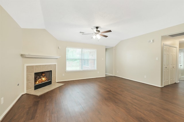 6611 Atasca Creek Dr, Humble, TX 77346 - unfurnished living room featuring a ceiling fan, dark wood-style floors, a tiled fireplace, and vaulted ceiling