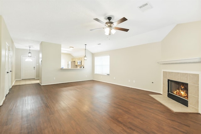 6611 Atasca Creek Dr, Humble, TX 77346 - unfurnished living room featuring lofted ceiling, ceiling fan, dark wood-type flooring, and a tiled fireplace