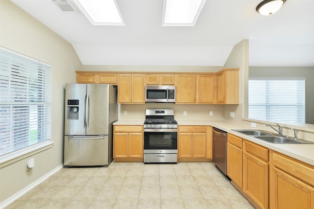 6611 Atasca Creek Dr, Humble, TX 77346 - kitchen with stainless steel appliances, lofted ceiling, light countertops, light brown cabinetry, and light tile patterned floors