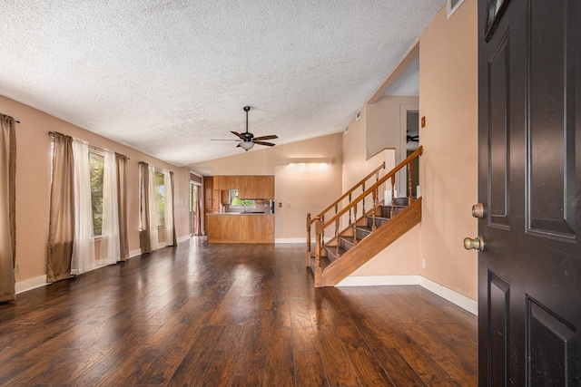 6302 Amie Ln, Pearland, TX 77584 - unfurnished living room featuring a textured ceiling, a ceiling fan, dark wood-style flooring, vaulted ceiling, and stairway