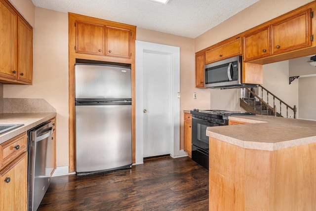 6302 Amie Ln, Pearland, TX 77584 - kitchen with stainless steel appliances, dark wood-style floors, a peninsula, light countertops, and brown cabinetry