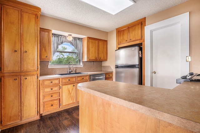 6302 Amie Ln, Pearland, TX 77584 - kitchen featuring stainless steel appliances, dark wood-style flooring, a textured ceiling, tasteful backsplash, and brown cabinets