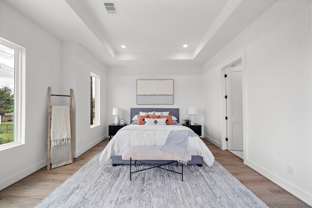 408 E 33rd St, Houston, TX 77018 - bedroom featuring light wood-style flooring, recessed lighting, and a tray ceiling