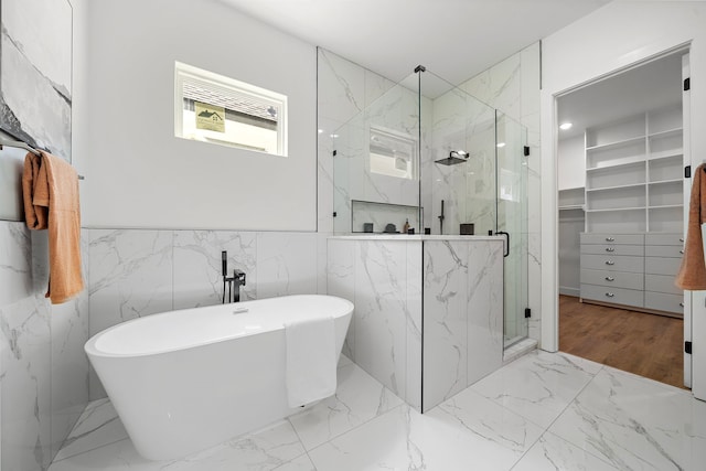 408 E 33rd St, Houston, TX 77018 - bathroom with a marble finish shower, a walk in closet, a soaking tub, marble finish floors, and a wainscoted wall