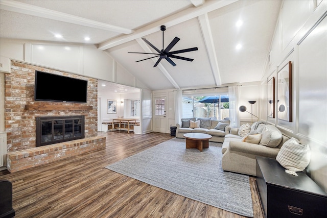 735 Rennie Dr, Katy, TX 77450 - living room with beam ceiling, wood finished floors, ceiling fan, a fireplace, and a decorative wall