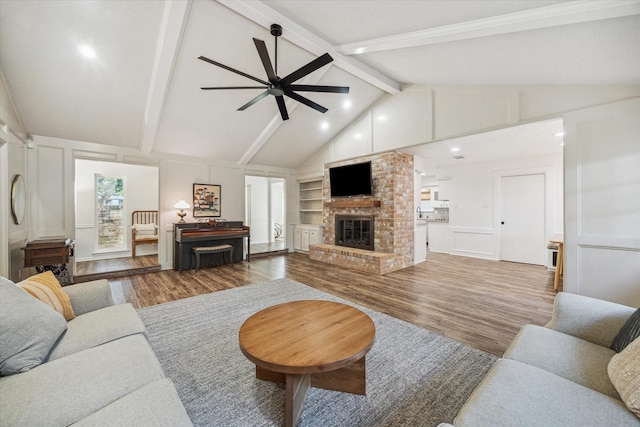 735 Rennie Dr, Katy, TX 77450 - living area featuring a decorative wall, wood finished floors, a brick fireplace, ceiling fan, and recessed lighting