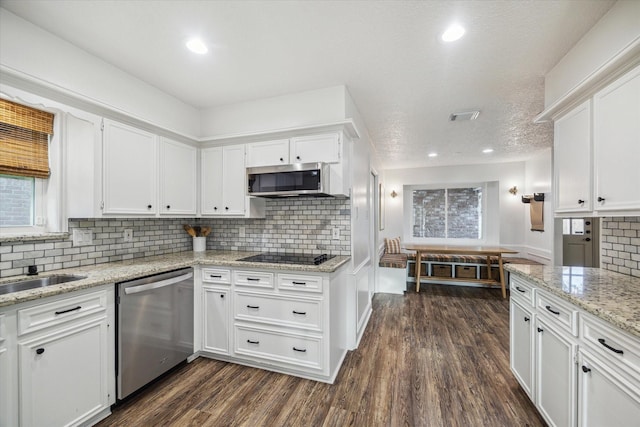 735 Rennie Dr, Katy, TX 77450 - kitchen with stainless steel appliances, white cabinets, decorative backsplash, dark wood-style flooring, and light stone countertops
