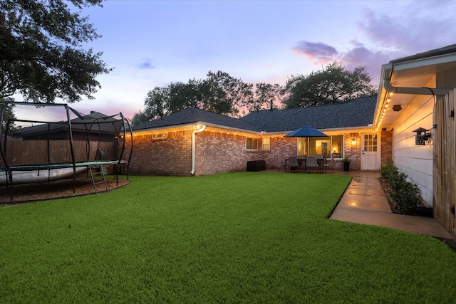 735 Rennie Dr, Katy, TX 77450 - view of grassy yard featuring a trampoline and a patio area
