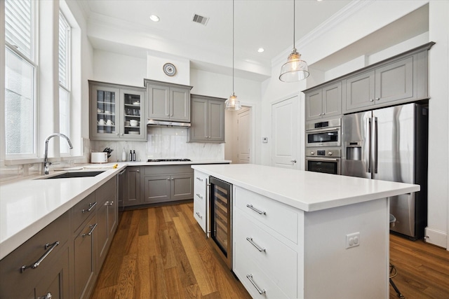 1240 W 16th St, Houston, TX 77008 - kitchen featuring appliances with stainless steel finishes, wine cooler, gray cabinetry, a center island, and crown molding