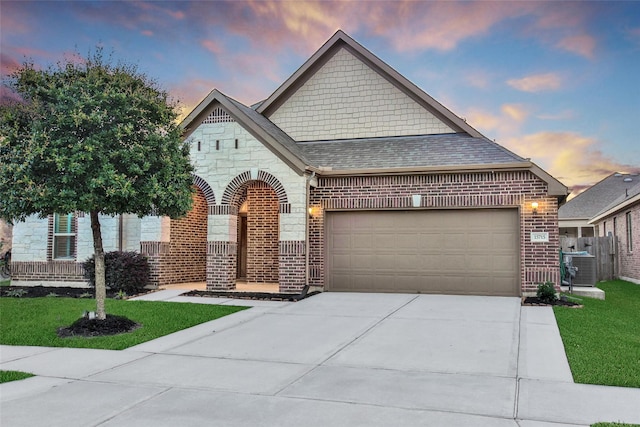 15715 Holloway Creek Ct, Houston, TX 77044 - french provincial home featuring a garage, brick siding, driveway, and a lawn