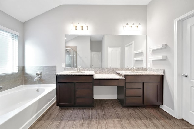15715 Holloway Creek Ct, Houston, TX 77044 - full bathroom featuring double vanity, a stall shower, wood finish floors, a garden tub, and lofted ceiling