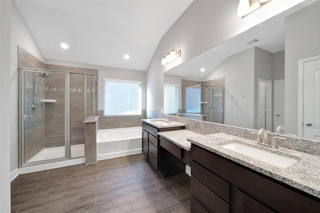 15715 Holloway Creek Ct, Houston, TX 77044 - full bathroom featuring lofted ceiling, vanity, a stall shower, a garden tub, and wood finished floors