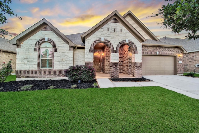 15715 Holloway Creek Ct, Houston, TX 77044 - french country inspired facade featuring stone siding, an attached garage, a lawn, and concrete driveway