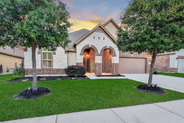 15715 Holloway Creek Ct, Houston, TX 77044 - view of front of property featuring stone siding, driveway, a lawn, and a garage