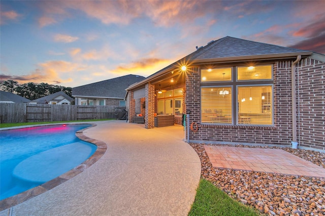 15715 Holloway Creek Ct, Houston, TX 77044 - pool at dusk with a fenced backyard, a patio area, and outdoor lounge area