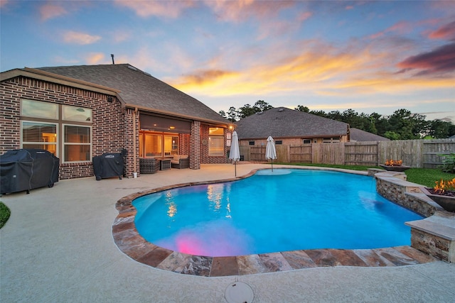 15715 Holloway Creek Ct, Houston, TX 77044 - pool at dusk with grilling area, a patio, and a fenced backyard