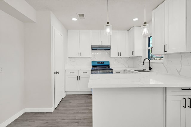 11807 Oceanview St, Missouri City, TX 77071 - kitchen with range, under cabinet range hood, white cabinets, decorative backsplash, and recessed lighting