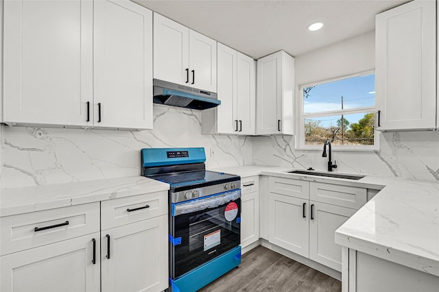 11807 Oceanview St, Missouri City, TX 77071 - kitchen featuring stainless steel electric stove, under cabinet range hood, white cabinetry, backsplash, and recessed lighting