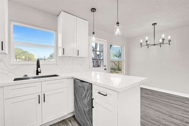 11807 Oceanview St, Missouri City, TX 77071 - kitchen featuring dishwashing machine, a peninsula, wood finished floors, decorative backsplash, and a chandelier