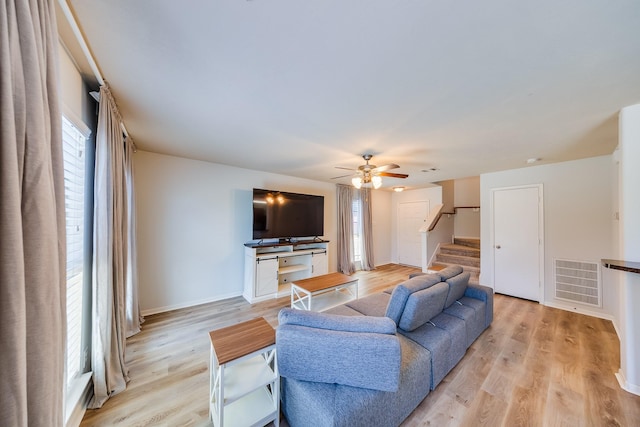 9415 Cholla Hill Ct, Houston, TX 77064 - living room with a ceiling fan, stairway, and light wood-style floors