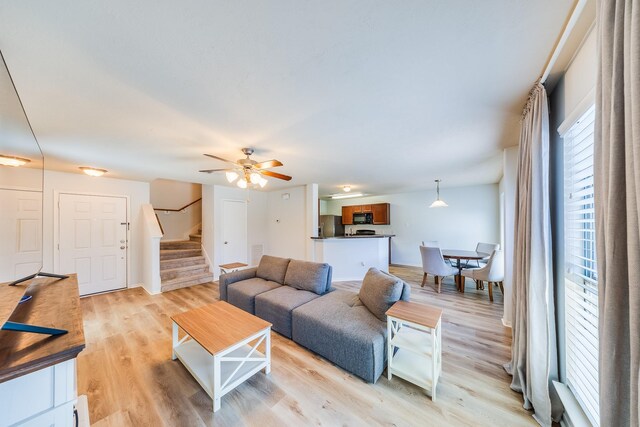 9415 Cholla Hill Ct, Houston, TX 77064 - living area featuring stairway, light wood finished floors, and a ceiling fan