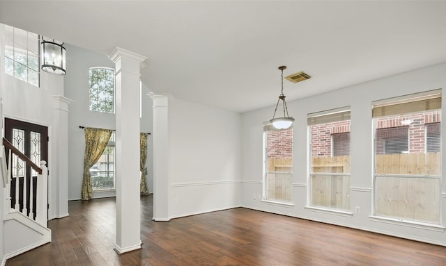 21331 Willow Glade Dr, Katy, TX 77450 - unfurnished dining area featuring dark wood-type flooring, plenty of natural light, ornate columns, and stairway
