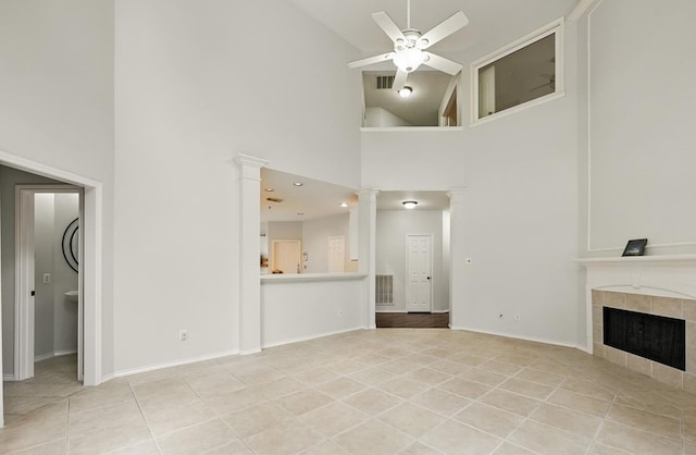 21331 Willow Glade Dr, Katy, TX 77450 - unfurnished living room featuring decorative columns, high vaulted ceiling, a ceiling fan, light tile patterned flooring, and a tiled fireplace
