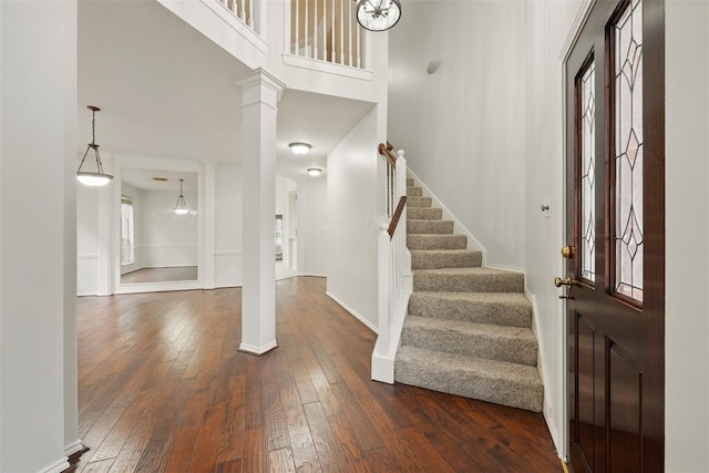 21331 Willow Glade Dr, Katy, TX 77450 - foyer entrance featuring decorative columns, dark wood-style flooring, stairs, and a towering ceiling