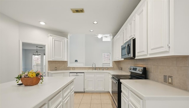 21331 Willow Glade Dr, Katy, TX 77450 - kitchen with stainless steel appliances, white cabinets, decorative backsplash, light countertops, and recessed lighting