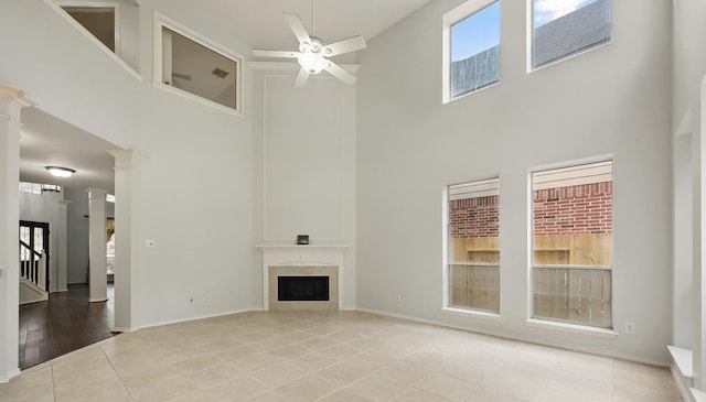 21331 Willow Glade Dr, Katy, TX 77450 - unfurnished living room with a towering ceiling, ceiling fan, light tile patterned floors, and a fireplace