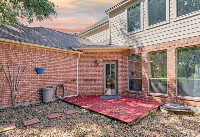 21331 Willow Glade Dr, Katy, TX 77450 - back of house at dusk with brick siding, a wooden deck, and roof with shingles
