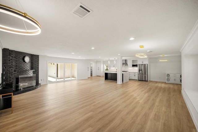 4302 Wigton Dr, Houston, TX 77096 - unfurnished living room featuring a fireplace, light wood finished floors, and recessed lighting