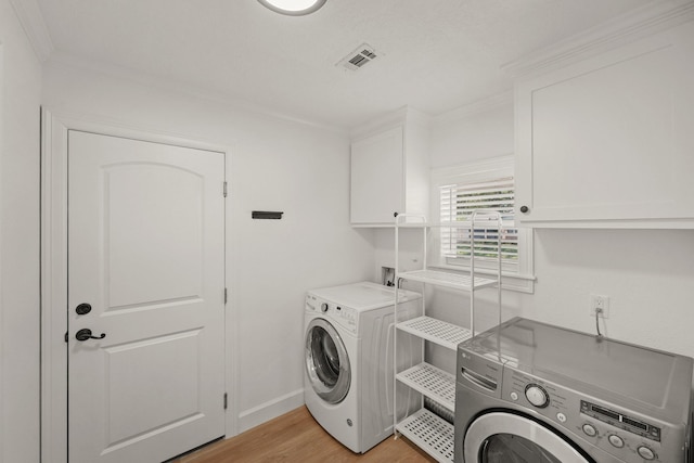 4302 Wigton Dr, Houston, TX 77096 - laundry area with cabinet space, separate washer and dryer, crown molding, and light wood-style floors