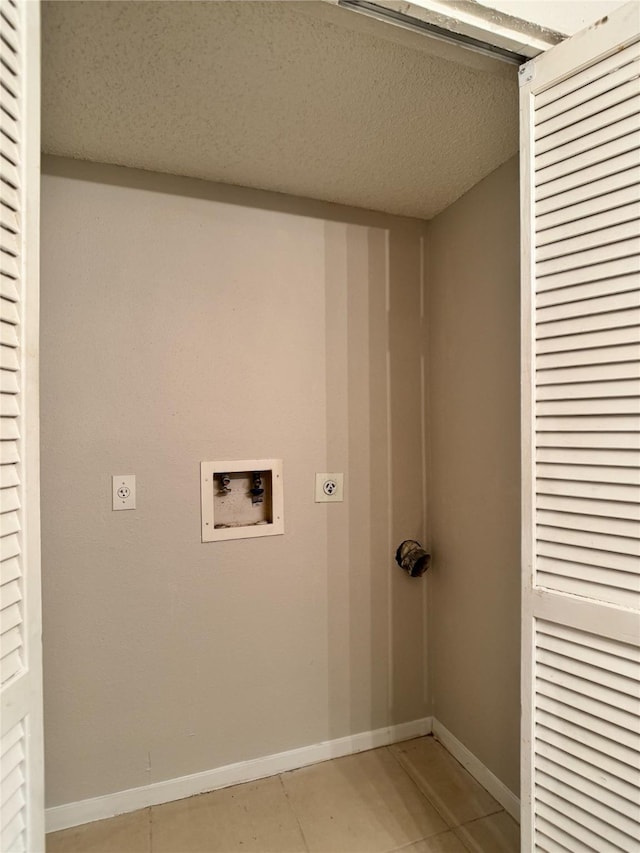 12991 Wirevine Ln, Houston, TX 77072 - washroom featuring electric dryer hookup, hookup for a washing machine, light tile patterned flooring, and a textured ceiling