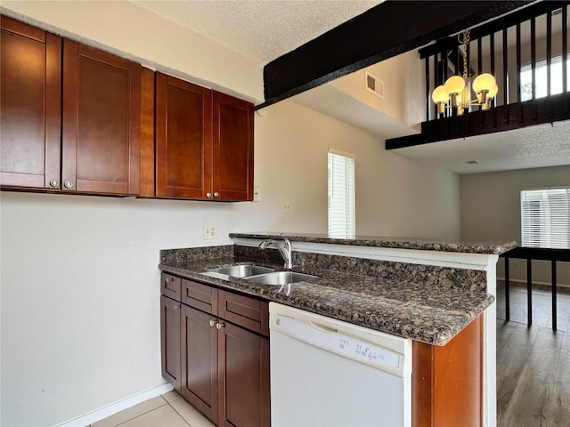 12991 Wirevine Ln, Houston, TX 77072 - kitchen featuring white dishwasher, a peninsula, a chandelier, a textured ceiling, and dark stone countertops