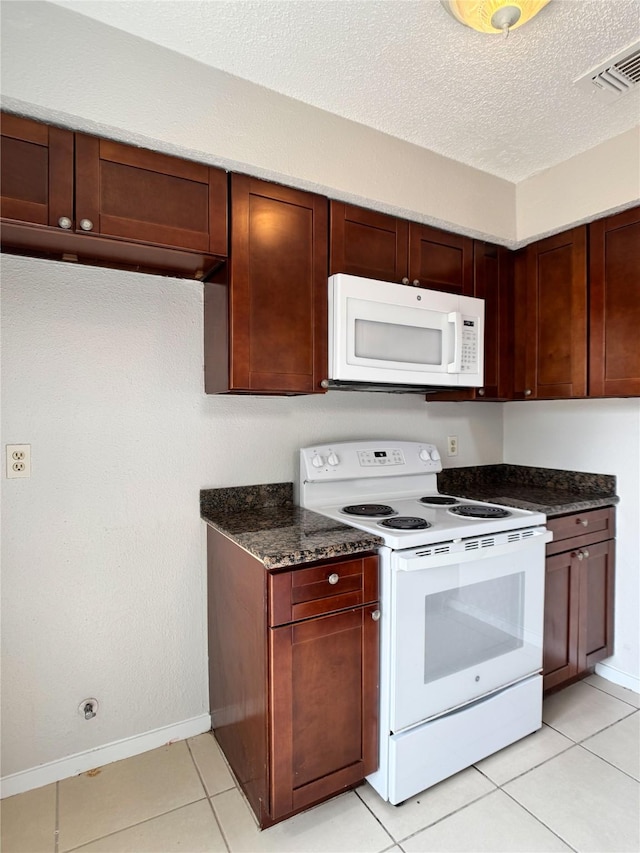 12991 Wirevine Ln, Houston, TX 77072 - kitchen with white appliances, dark stone counters, light tile patterned floors, and a textured ceiling