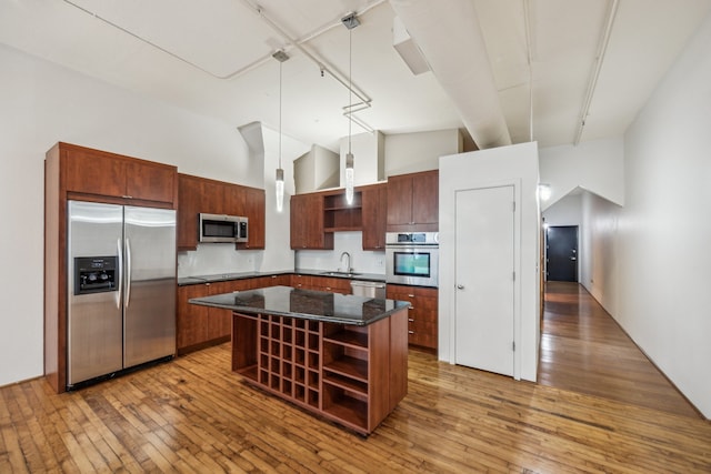 705 Main St Unit 302, Houston, TX 77002 - kitchen featuring stainless steel appliances, open shelves, a center island, light wood-style floors, and high vaulted ceiling