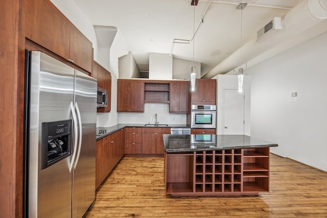 705 Main St Unit 302, Houston, TX 77002 - kitchen featuring open shelves, appliances with stainless steel finishes, light wood-style flooring, hanging light fixtures, and a kitchen island