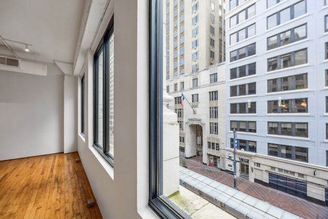 705 Main St Unit 302, Houston, TX 77002 - hall featuring rail lighting, healthy amount of natural light, and wood finished floors