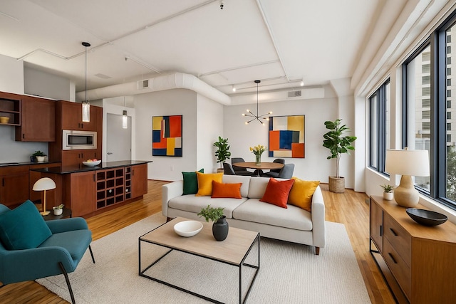 705 Main St Unit 302, Houston, TX 77002 - living room featuring light wood finished floors, a chandelier, and track lighting