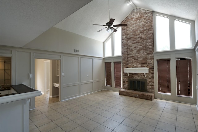 20246 Pittsford Dr, Katy, TX 77450 - unfurnished living room featuring a decorative wall, ceiling fan, light tile patterned flooring, high vaulted ceiling, and a textured ceiling