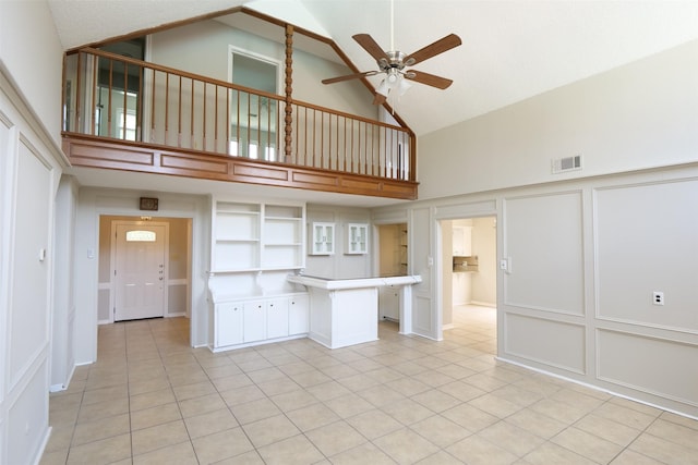 20246 Pittsford Dr, Katy, TX 77450 - unfurnished living room featuring high vaulted ceiling, ceiling fan, a decorative wall, light tile patterned floors, and a wainscoted wall