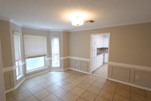 20246 Pittsford Dr, Katy, TX 77450 - unfurnished room with a textured ceiling, crown molding, light tile patterned floors, a wainscoted wall, and a decorative wall