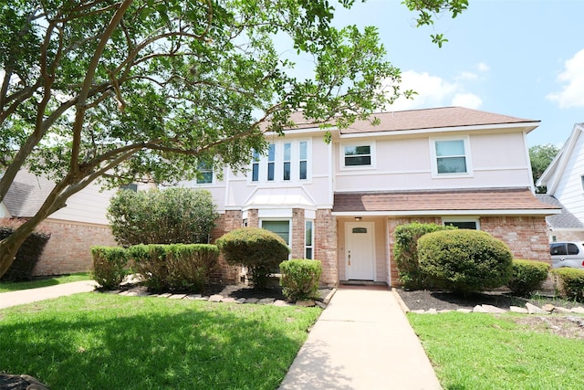 20246 Pittsford Dr, Katy, TX 77450 - traditional-style home featuring brick siding, a front yard, roof with shingles, and stucco siding